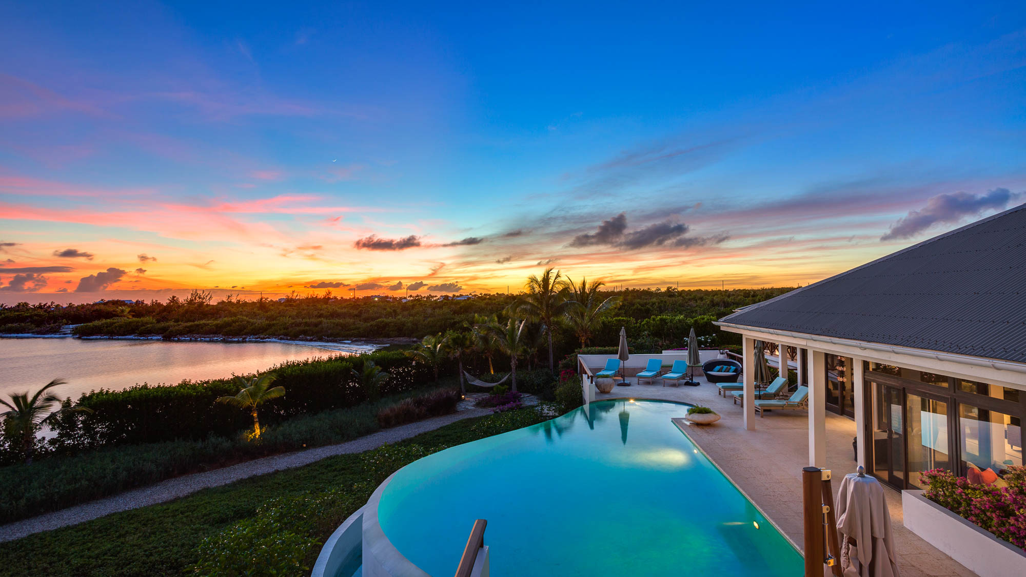 Villa roofline and garden at sunset